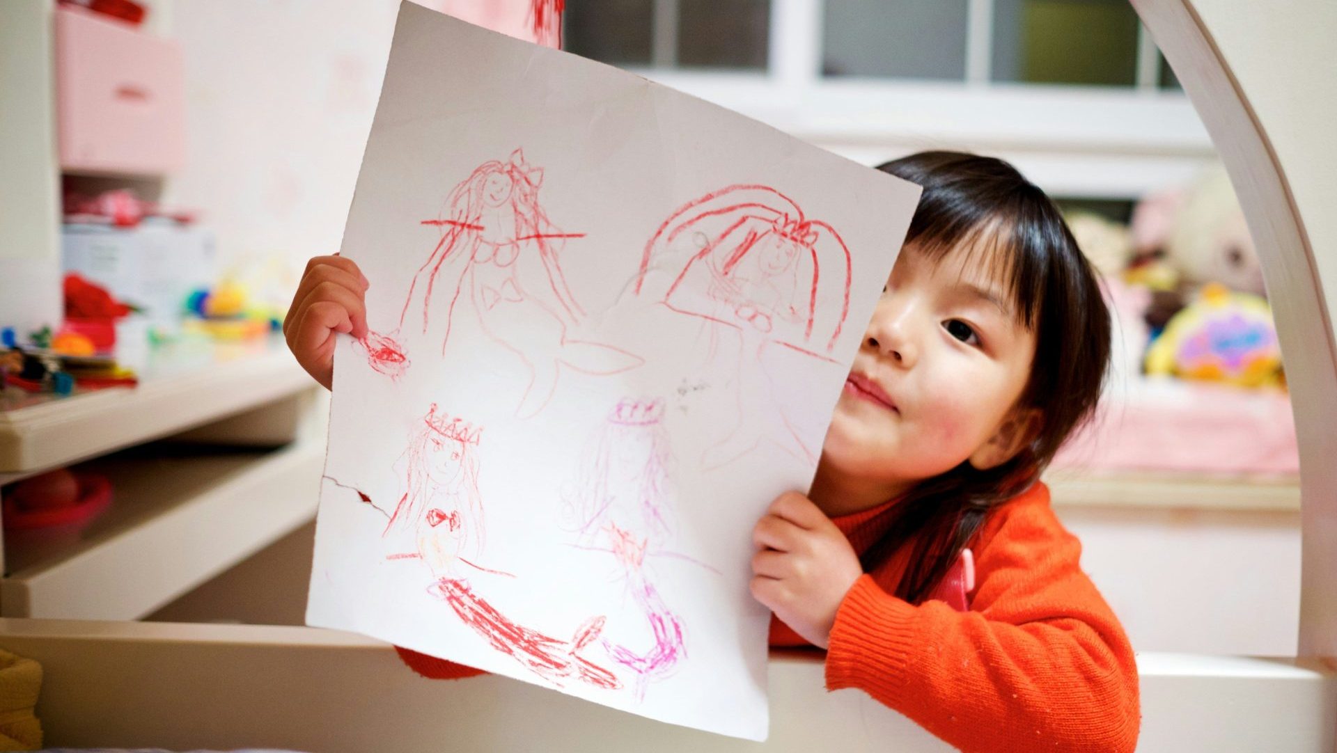 girl holding paper with drawing